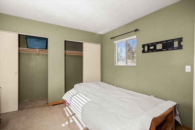 carpeted bedroom with two closets