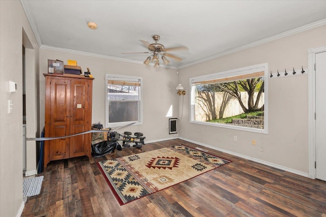 interior space with crown molding, ceiling fan, wood finished floors, and baseboards