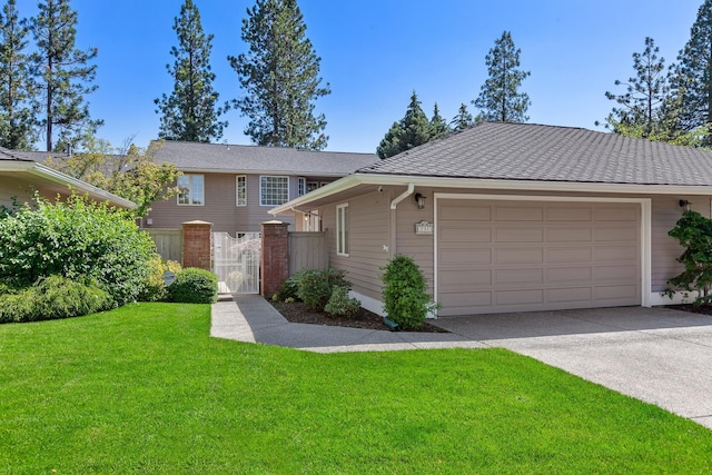 view of front of house with a front yard, driveway, a gate, and an attached garage