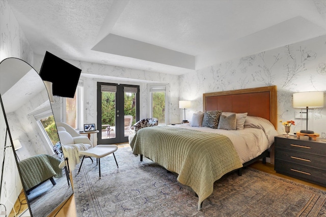 bedroom with french doors, access to exterior, wallpapered walls, and a textured ceiling