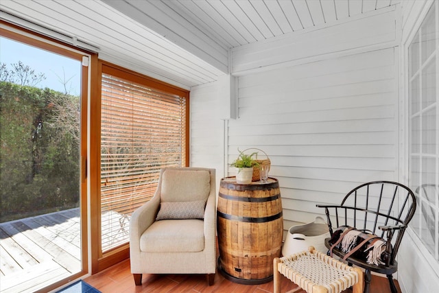 sitting room featuring wood finished floors and wooden walls