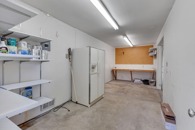 below grade area featuring white fridge with ice dispenser
