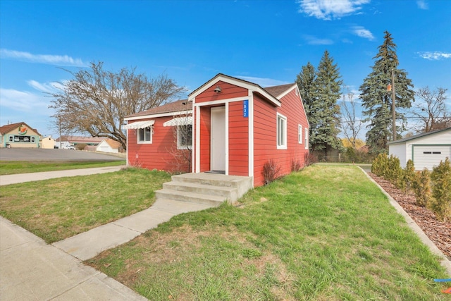 view of front of house with a shingled roof and a front lawn
