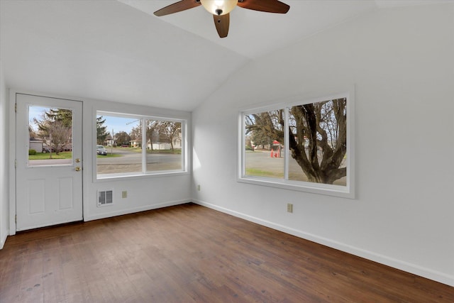 empty room featuring wood finished floors, visible vents, a ceiling fan, and lofted ceiling