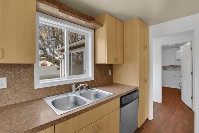 kitchen featuring light brown cabinetry, stainless steel dishwasher, a sink, and decorative backsplash