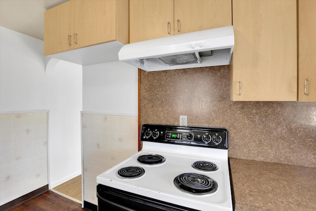 kitchen with light brown cabinets, electric stove, dark wood finished floors, under cabinet range hood, and decorative backsplash