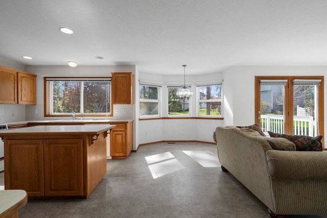 kitchen featuring a wealth of natural light, recessed lighting, a kitchen island, and a notable chandelier