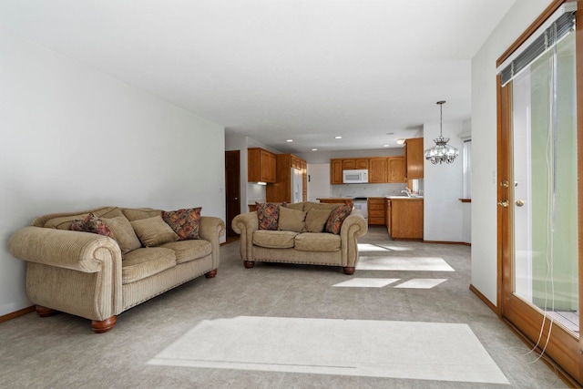 living room with a chandelier, recessed lighting, baseboards, and light colored carpet