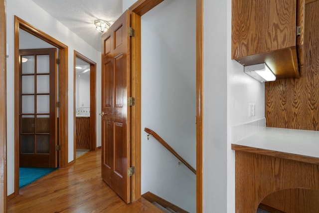 hallway with an upstairs landing and light wood-style flooring