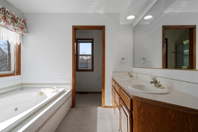 bathroom featuring a sink, double vanity, a tub with jets, and a shower with shower door