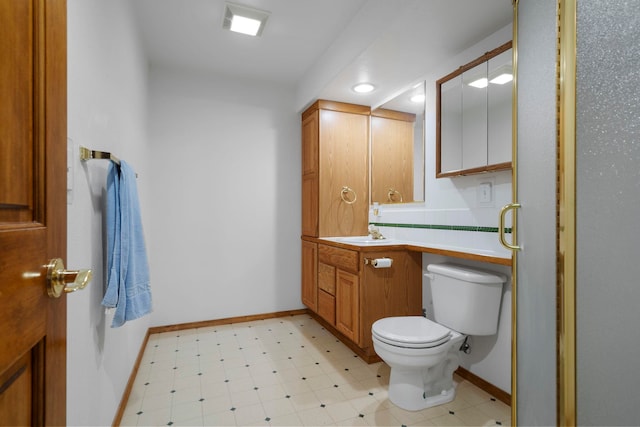 bathroom with toilet, tile patterned floors, vanity, and baseboards