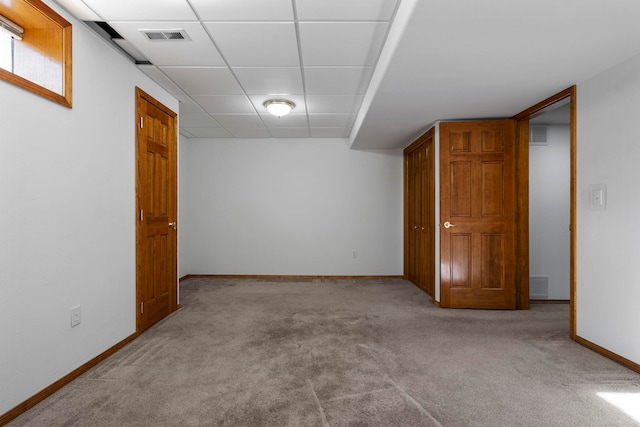 finished basement featuring carpet floors, baseboards, a drop ceiling, and visible vents