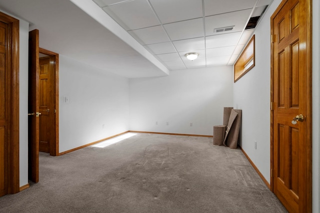 finished basement with visible vents, baseboards, a paneled ceiling, and carpet floors