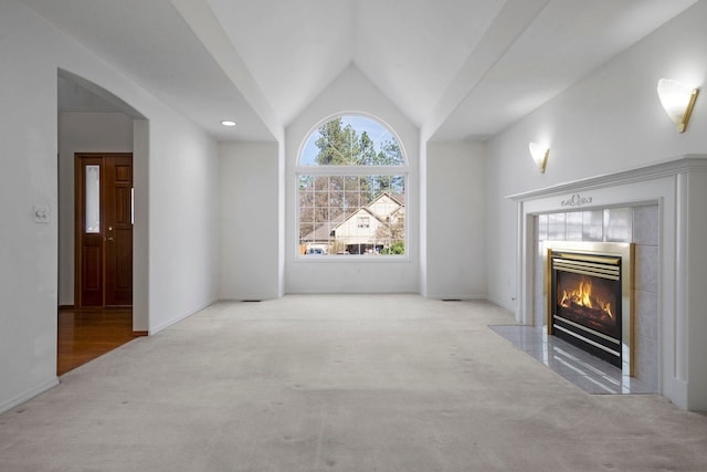 unfurnished living room featuring lofted ceiling, carpet, baseboards, and a fireplace