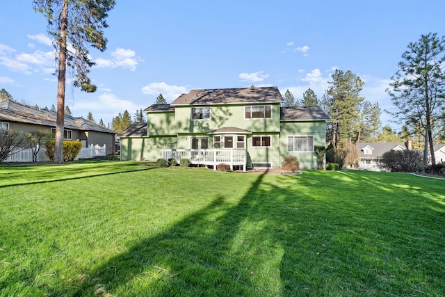 back of house featuring a wooden deck and a lawn