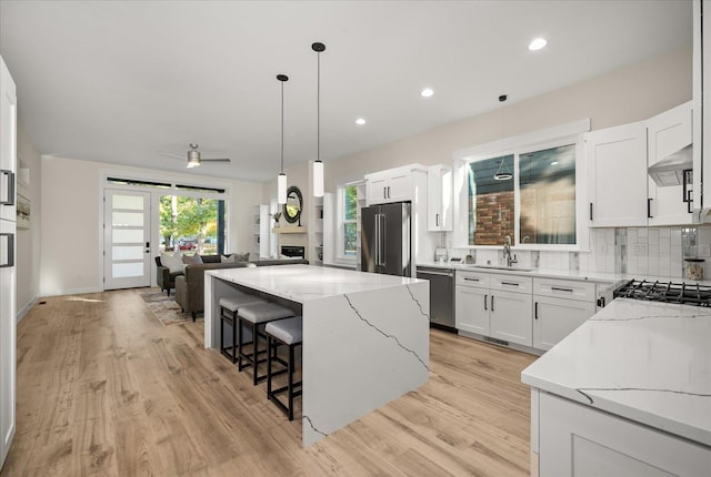 3022 S Manito Blvd, Spokane, WA 99203 - kitchen featuring a center island, a sink, open floor plan, light stone counters, and appliances with stainless steel finishes