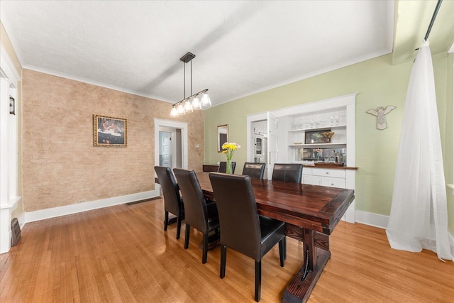 dining space with light wood-type flooring, baseboards, and ornamental molding