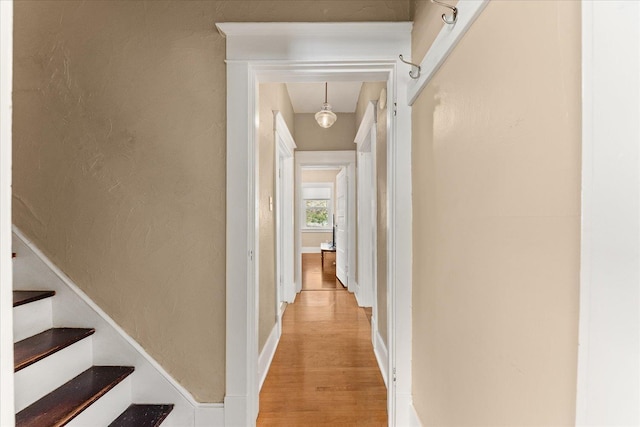 hallway with light wood-style flooring and stairs
