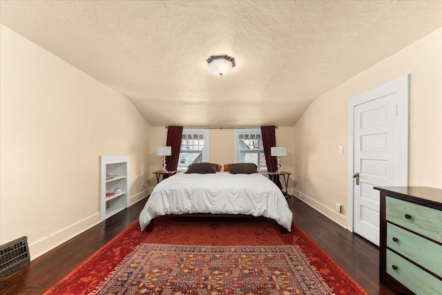 bedroom with baseboards, vaulted ceiling, visible vents, and dark wood finished floors
