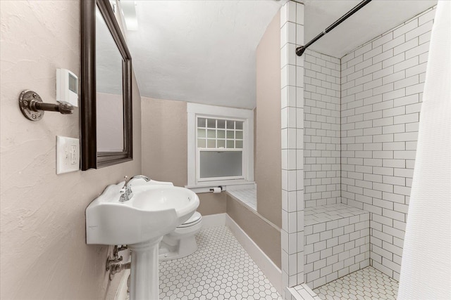bathroom featuring toilet and a stall shower