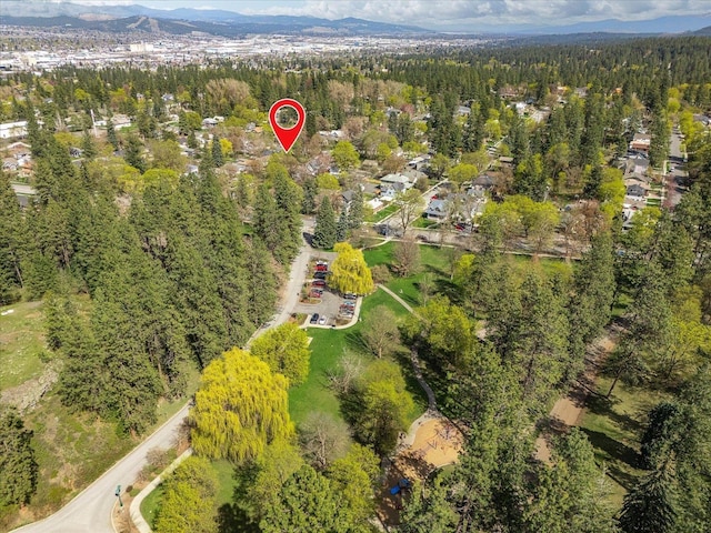 drone / aerial view featuring a mountain view and a view of trees