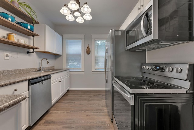 1303 E Rich Ave, Spokane, WA 99207 - kitchen featuring stainless steel appliances, an inviting chandelier, open shelves, a sink, and white cabinetry