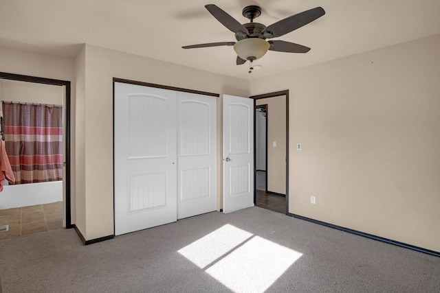 unfurnished bedroom featuring baseboards, carpet floors, ensuite bathroom, and a closet
