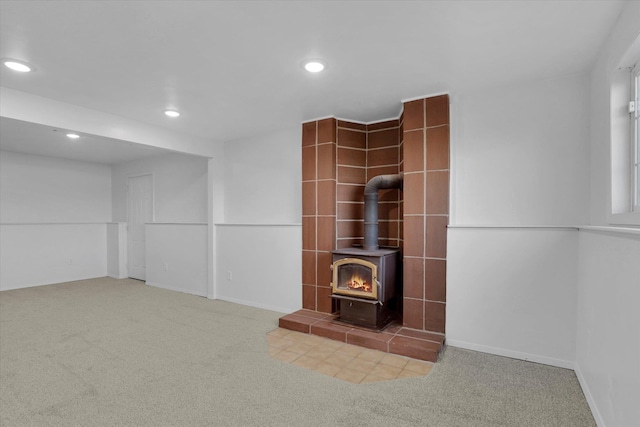 unfurnished living room with recessed lighting, a wood stove, carpet flooring, and baseboards