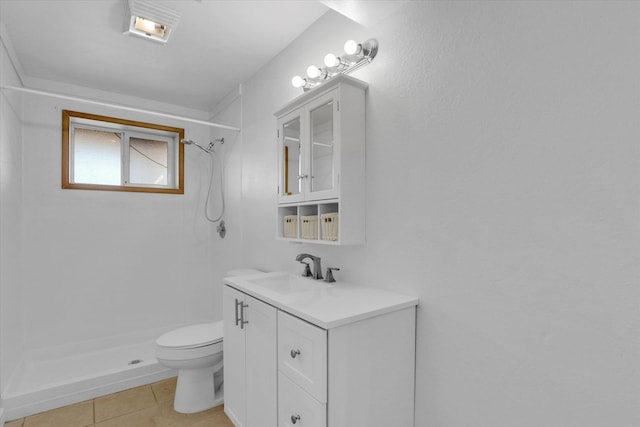 bathroom with toilet, vanity, tile patterned flooring, and a stall shower