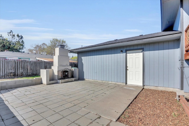 view of patio / terrace with fence and an outdoor fireplace
