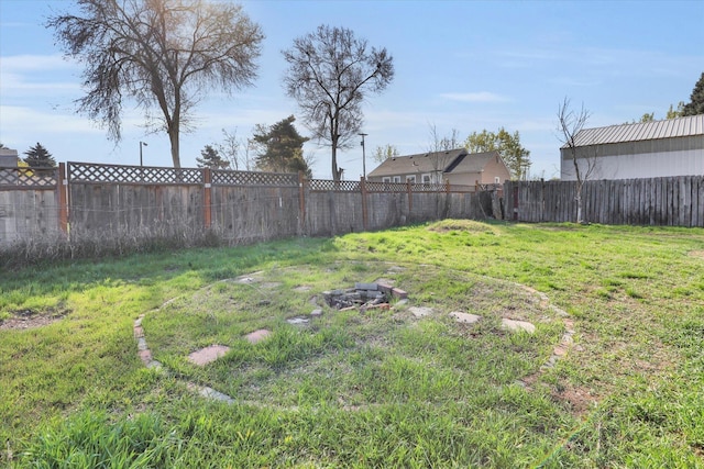 view of yard with a fenced backyard and an outdoor fire pit