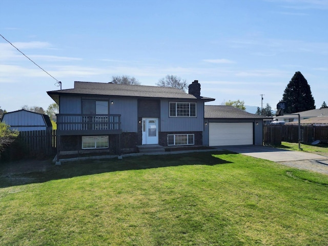 raised ranch featuring concrete driveway, fence, a front yard, and a garage