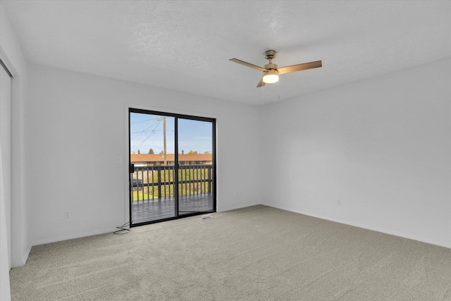 carpeted empty room with a ceiling fan and baseboards