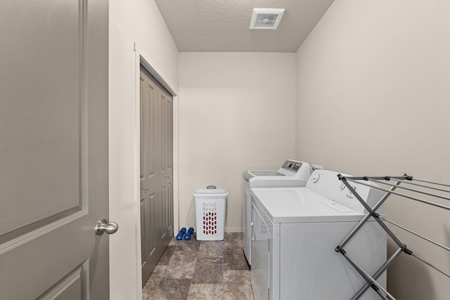 12827 W 3rd Ave, Airway Heights, WA 99001 - laundry room with separate washer and dryer, a textured ceiling, and dark stone finish flooring