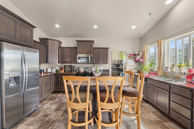 12827 W 3rd Ave, Airway Heights, WA 99001 - kitchen with appliances with stainless steel finishes, dark brown cabinetry, stone finish flooring, and recessed lighting