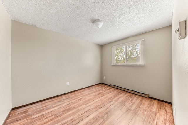 2310 E 1st Ave, Spokane, WA 99202 - spare room featuring baseboard heating, baseboards, a textured ceiling, and light wood-style flooring