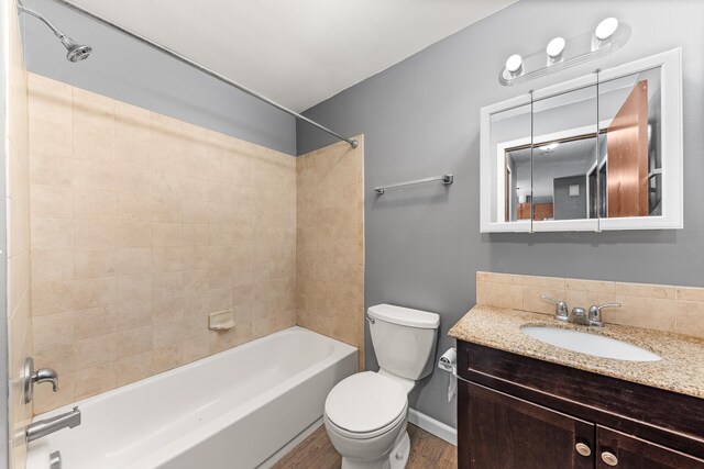 2310 E 1st Ave, Spokane, WA 99202 - full bathroom featuring wood finished floors, vanity, tub / shower combination, baseboards, and toilet