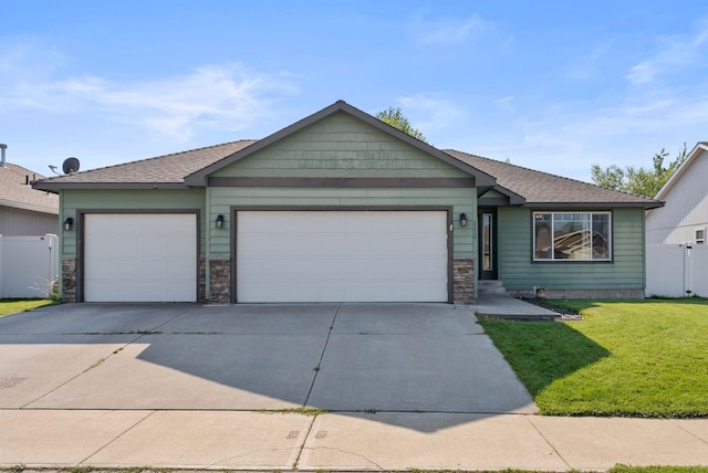 112 S Holiday Rd, Spokane Valley, WA 99016 - ranch-style house featuring concrete driveway, a front lawn, stone siding, and a garage