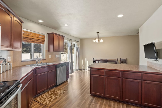 112 S Holiday Rd, Spokane Valley, WA 99016 - kitchen featuring a sink, decorative backsplash, stainless steel appliances, a notable chandelier, and dark wood-style floors