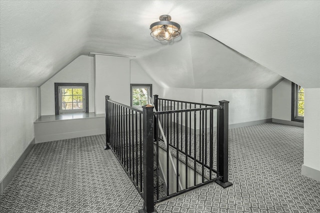 530 E 11th Ave, Spokane, WA 99202 - additional living space featuring carpet floors, baseboards, vaulted ceiling, and a textured ceiling