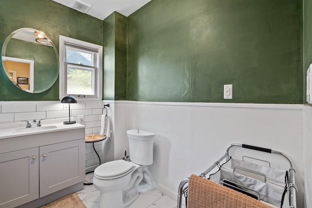1607 W 11th Ave, Spokane, WA 99204 - bathroom with vanity, marble look tiles, and a wainscoted wall