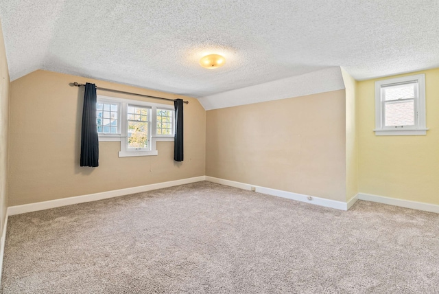 1607 W 11th Ave, Spokane, WA 99204 - empty room with vaulted ceiling, carpet, a textured ceiling, and plenty of natural light