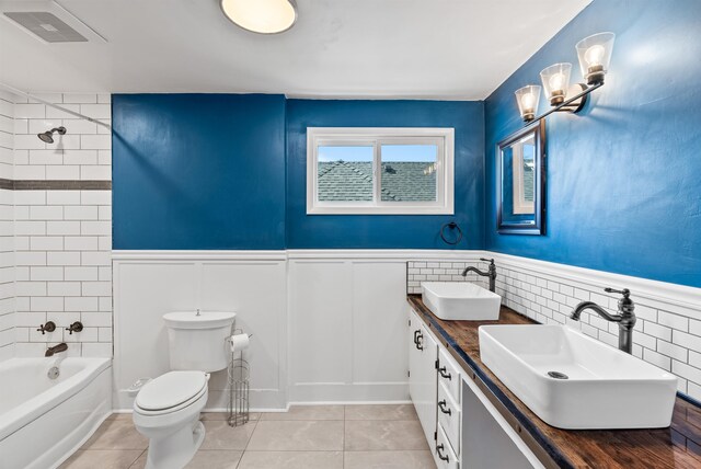 1607 W 11th Ave, Spokane, WA 99204 - bathroom featuring double vanity, shower / tub combination, a wainscoted wall, and tile patterned flooring