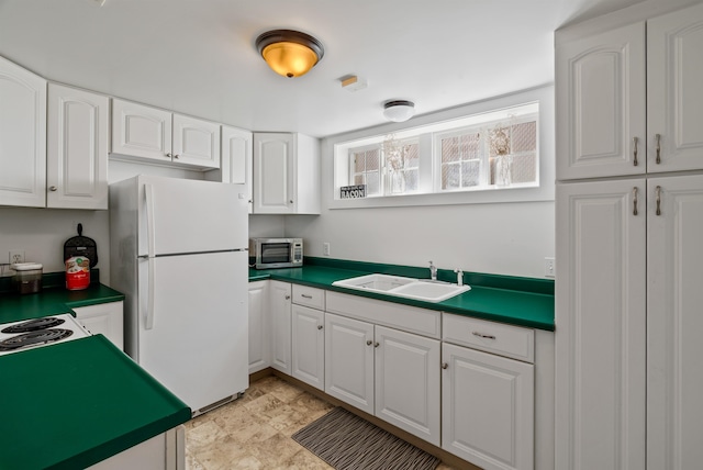1607 W 11th Ave, Spokane, WA 99204 - kitchen featuring freestanding refrigerator, stainless steel microwave, white cabinetry, and dark countertops