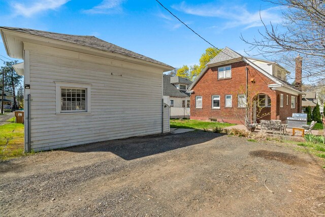 1607 W 11th Ave, Spokane, WA 99204 - view of side of home with a patio area and a shingled roof