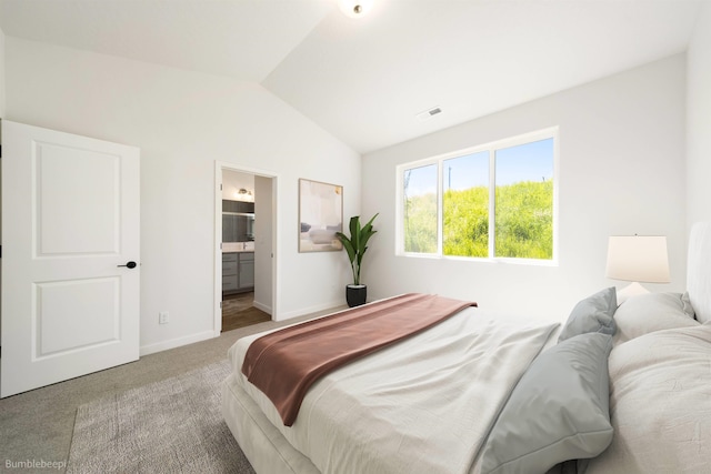 bedroom featuring ensuite bath, baseboards, vaulted ceiling, and carpet