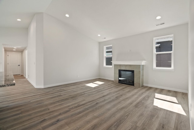 unfurnished living room featuring visible vents, a tile fireplace, wood finished floors, and recessed lighting