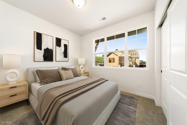 carpeted bedroom featuring a closet, visible vents, and baseboards