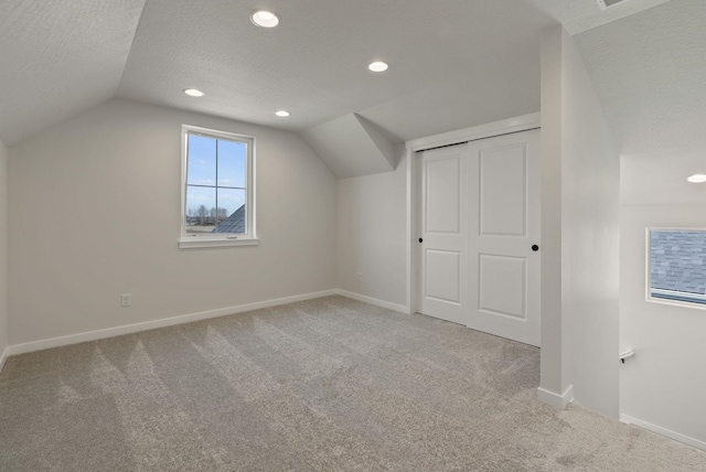 bonus room with baseboards, vaulted ceiling, and carpet