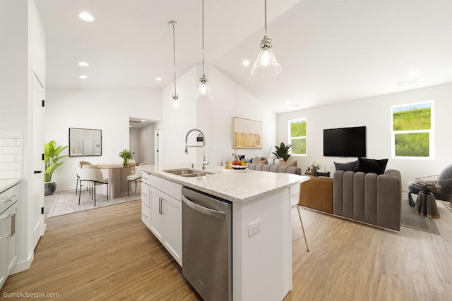 kitchen featuring a kitchen island with sink, stainless steel dishwasher, a sink, light wood-style floors, and white cabinetry